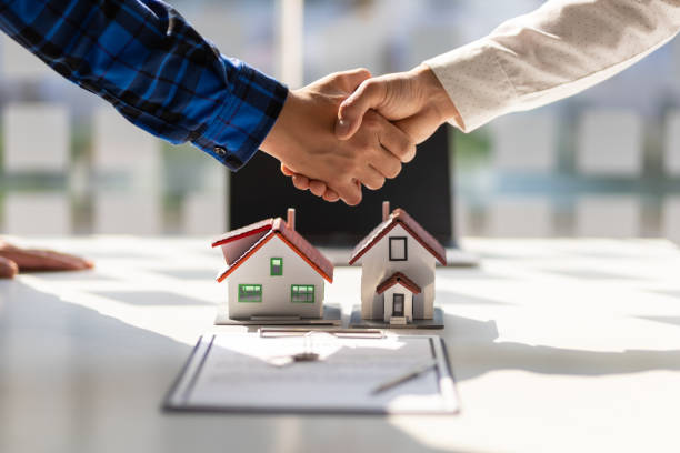 Real estate agents shake hands after the signing of the contract agreement is complete.